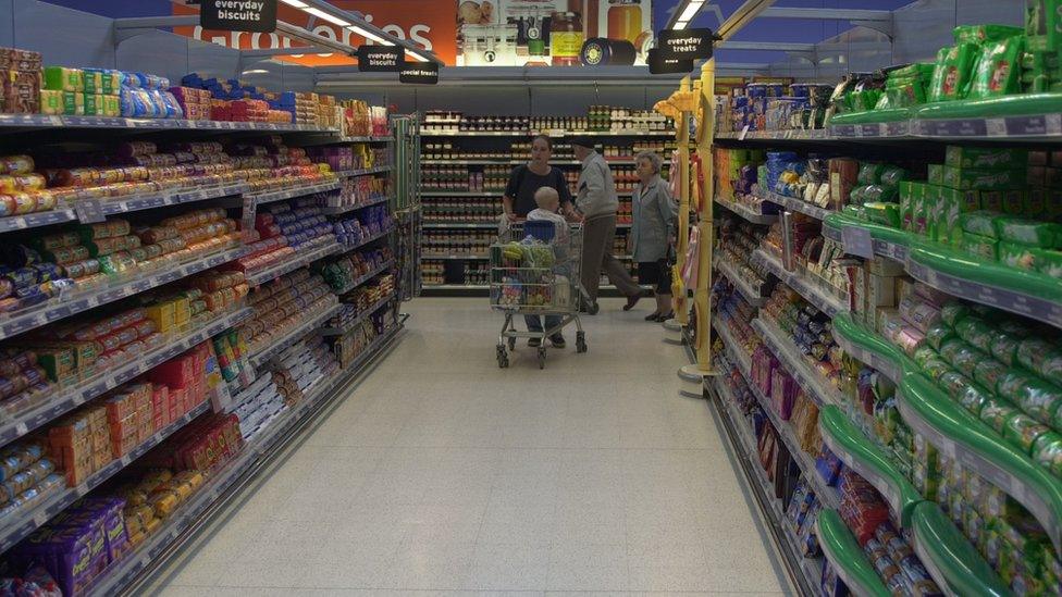 A woman shopping in a Sainsbury's grocery aisle