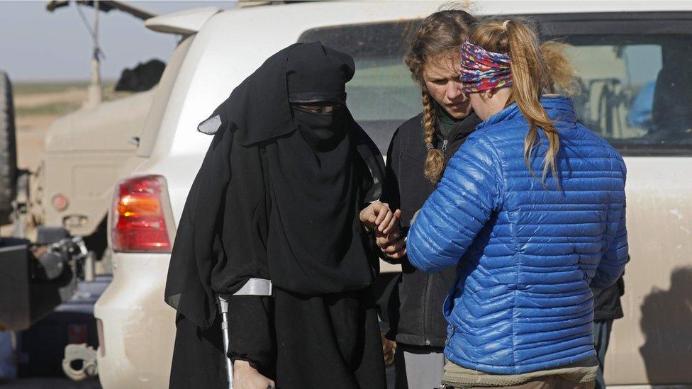 A woman waits to be screened by members of the US-backed Syrian Democratic Forces