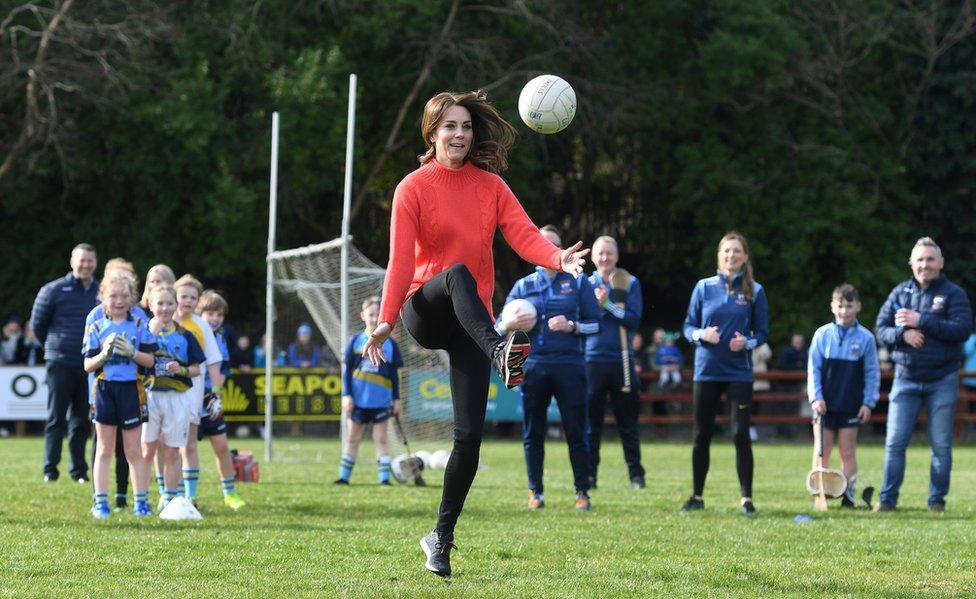 Kate kicks a Gaelic football during a visit to Salthill Knocknacarra GAA club