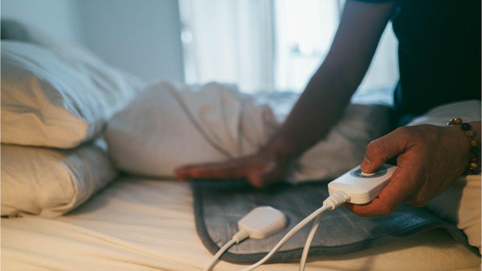 A man holding electric blanket control