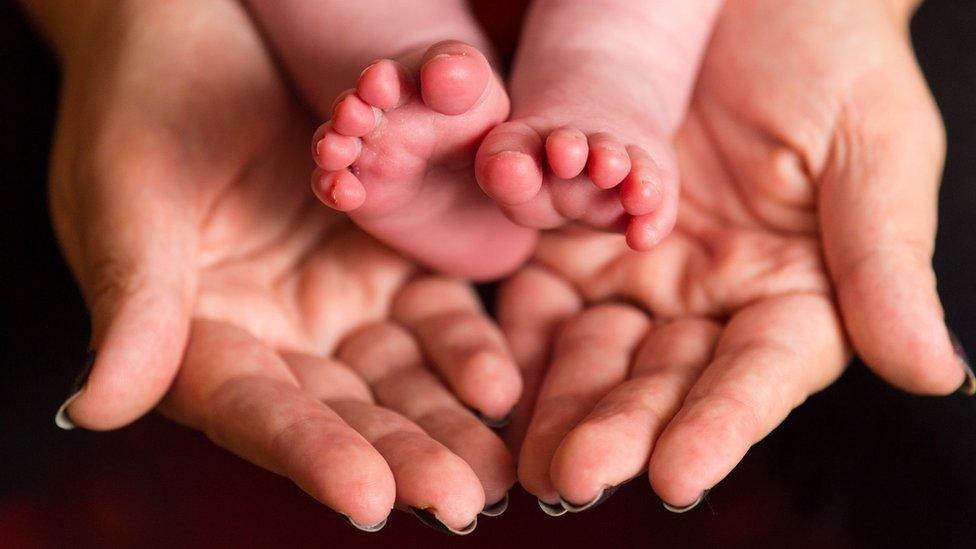 Baby feet in mother's hands