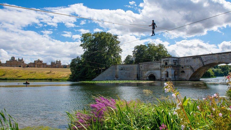 Tightrope walker suspended above Queen Lake