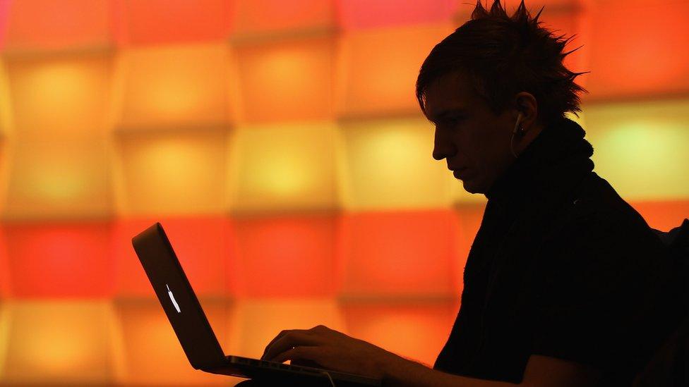 silhouette of man at laptop