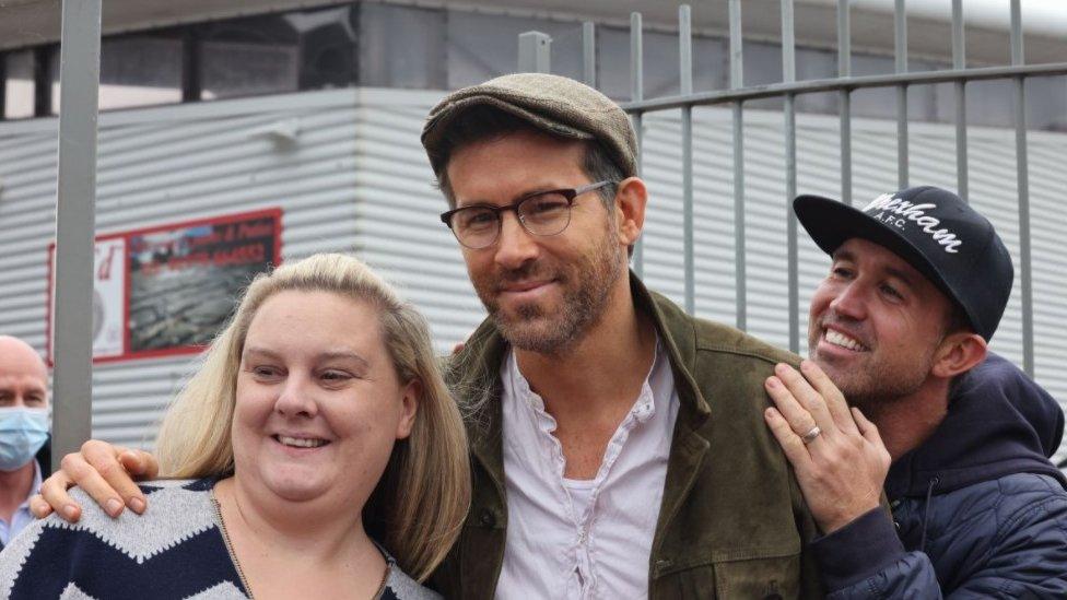 Rob McElhenney and Ryan Reynolds with a Wrexham fan