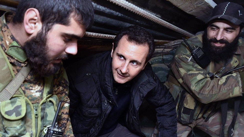 In this Wednesday, Dec. 31, 2014, file photo released by the Syrian official news agency SANA, Syrian President Bashar Assad, center, speaks with Syrian troops