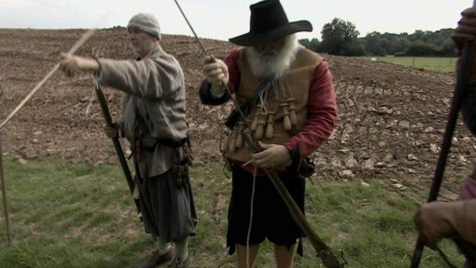 A re-enactor wearing gunpowder flasks