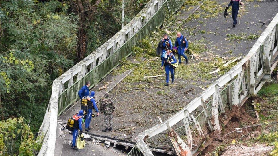 Rescuers walk on a suspension bridge which collapsed on 18 November 18 in Mirepoix-sur-Tarn, near Toulouse, south-west France