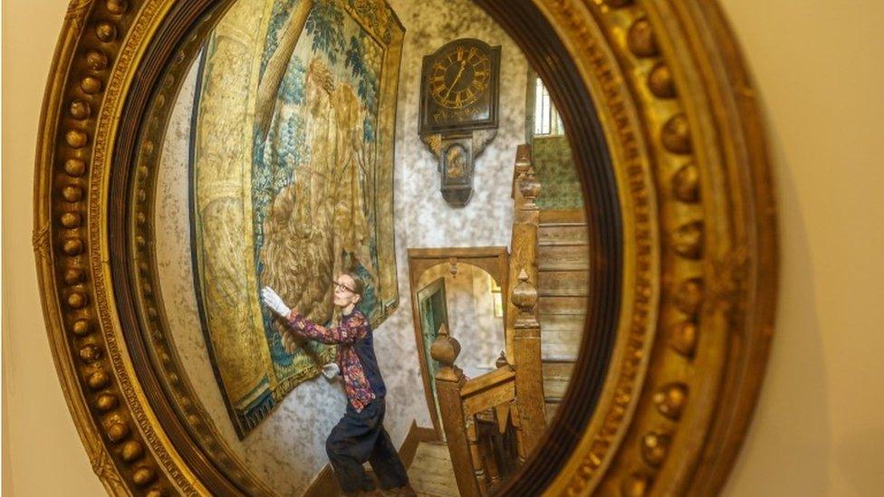 Staff adjust a tapestry in Kelmscott Manor