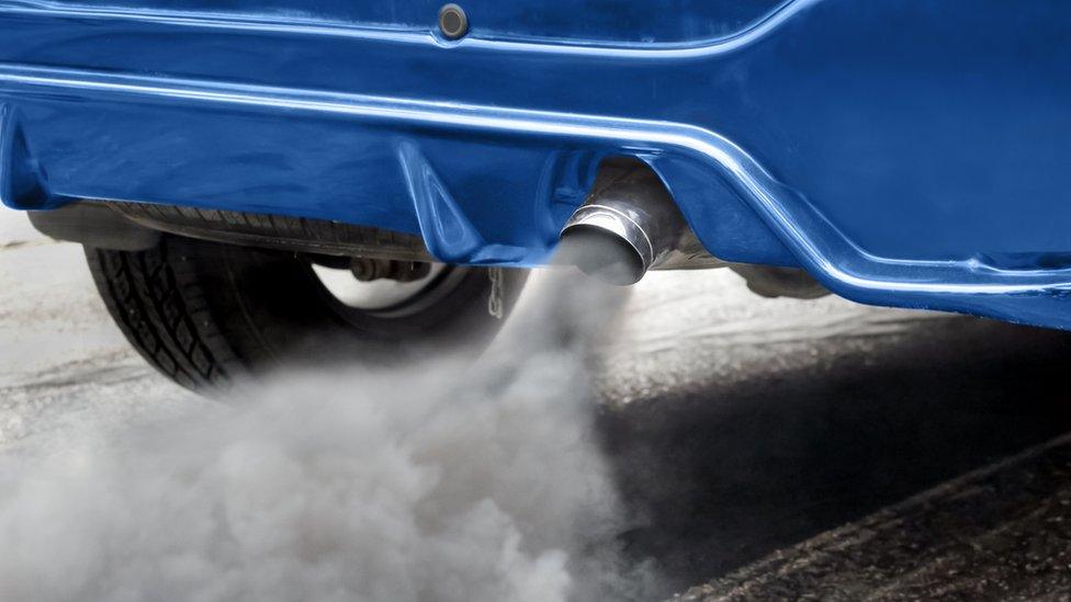 Air pollution from vehicle exhaust pipe on road