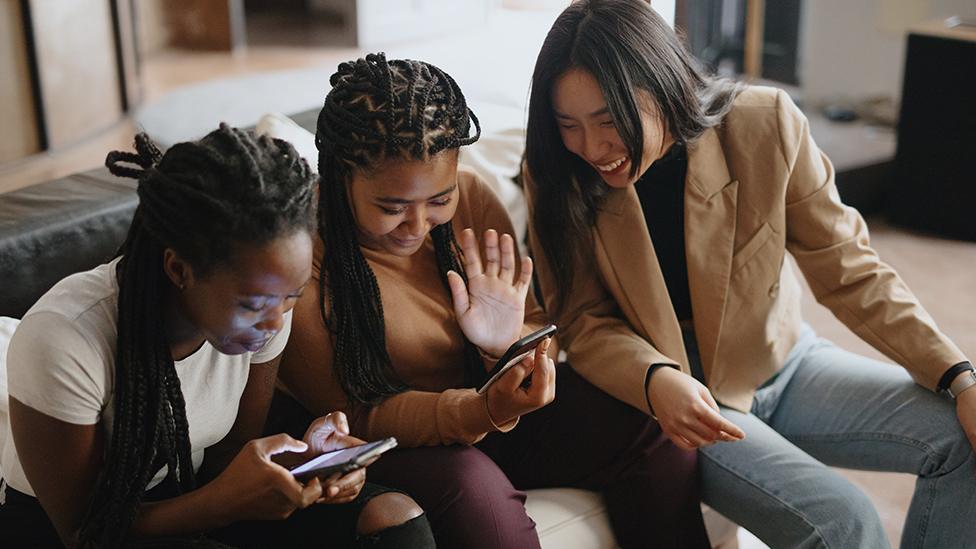 Three girls looking at a phone