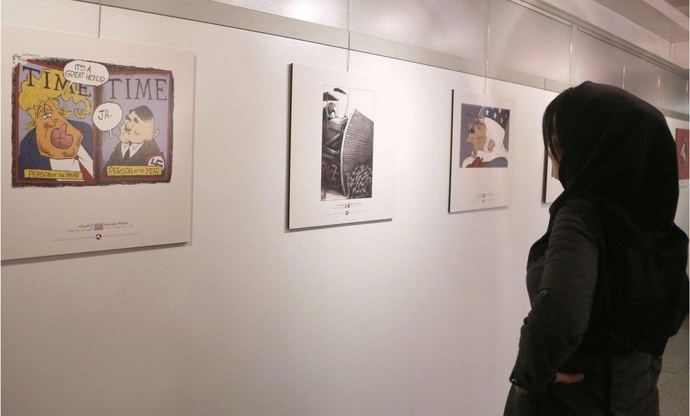 An Iranian woman looks at cartoons of US President Donald Trump at an exhibition of the Islamic Republic's 2017 International Trumpism cartoon and caricature contest, in the capital Tehran on 3 July 2017