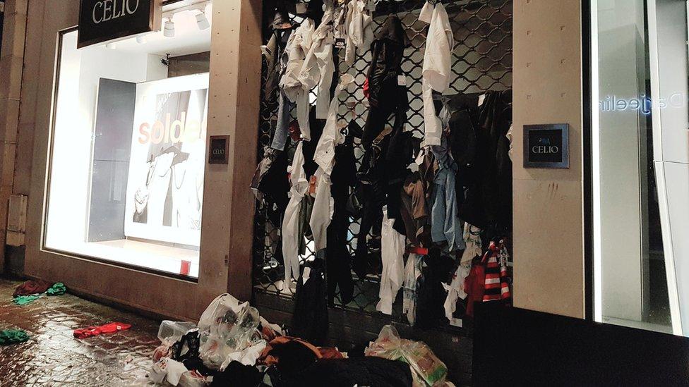 Torn-up clothes abandoned on Celio's roller shutter grilles