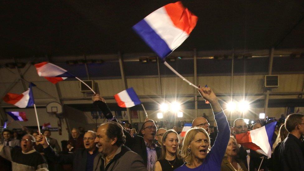 Supporters of far right National Front party regional leader for southeastern France, Marion Marechal-Le Pen, wave flags at a meeting after the results of the first round of the regional elections, in Carpentras, southern France, Sunday, Dec. 6, 2015.