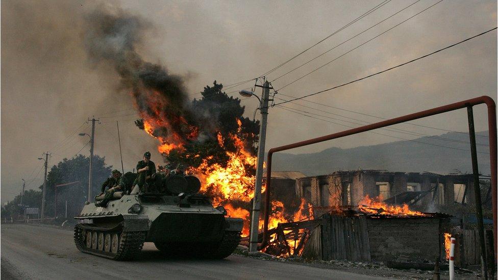 Russian armoured troop carrier next to house set on fire by South Ossetian militia in the village of Kvemo-Achebeti, Georgia (file photo - August 2008)