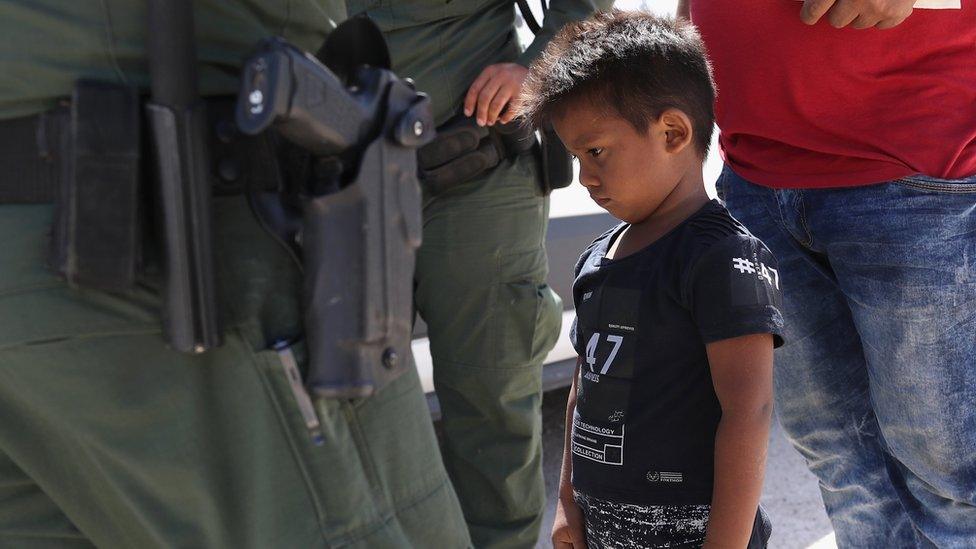 A boy and father from Honduras are taken into custody by US Border Patrol agents near the US-Mexico Border on 12 June, 2018 near Mission, Texas.