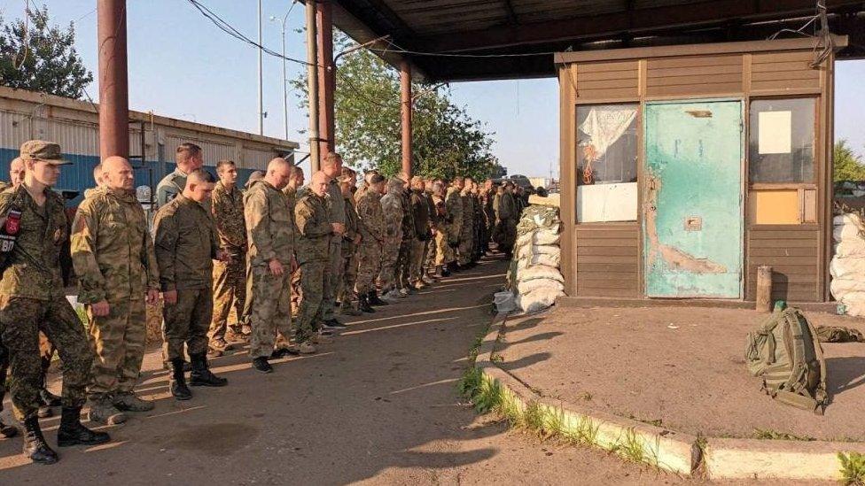 Photo released by Wagner allegedly shows Russian border guards at a checkpoint laying down their weapons