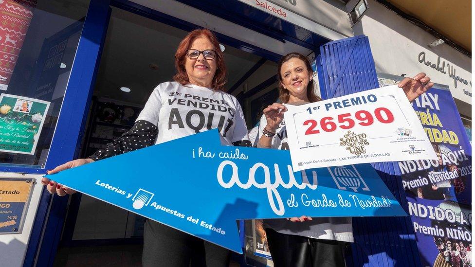 Owner of the lottery administration Virgen de La Salceda, Fuensanta Vicente (R), celebrates selling the first prize ticket in Murcia.