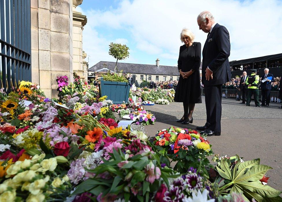 King Charles and Camilla look at the thousands of floral tributes left at the gates of Hillsborough Castle in honour of Queen Elizabeth II