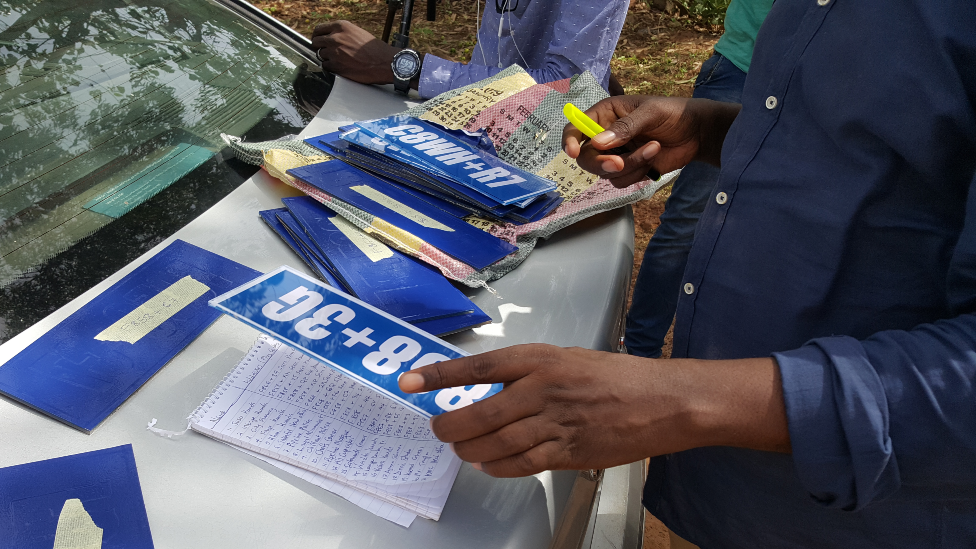 The plus code signs and a list of where they need to go - The Gambia