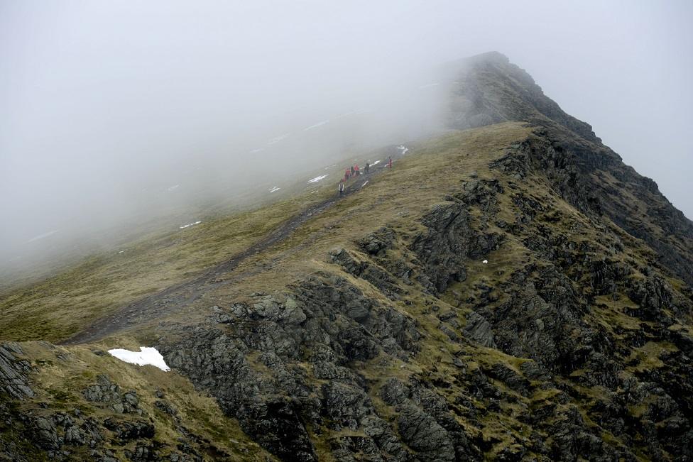 Walkers on a path on a mountain ridge in Britain