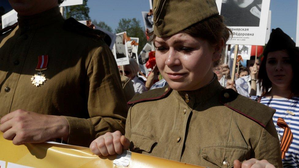 A woman cries as she takes part in the Immortal Regiment march during the Victory Day celebrations in Riga, Latvia, May 9, 2016. REUTERS/Ints Kalnins