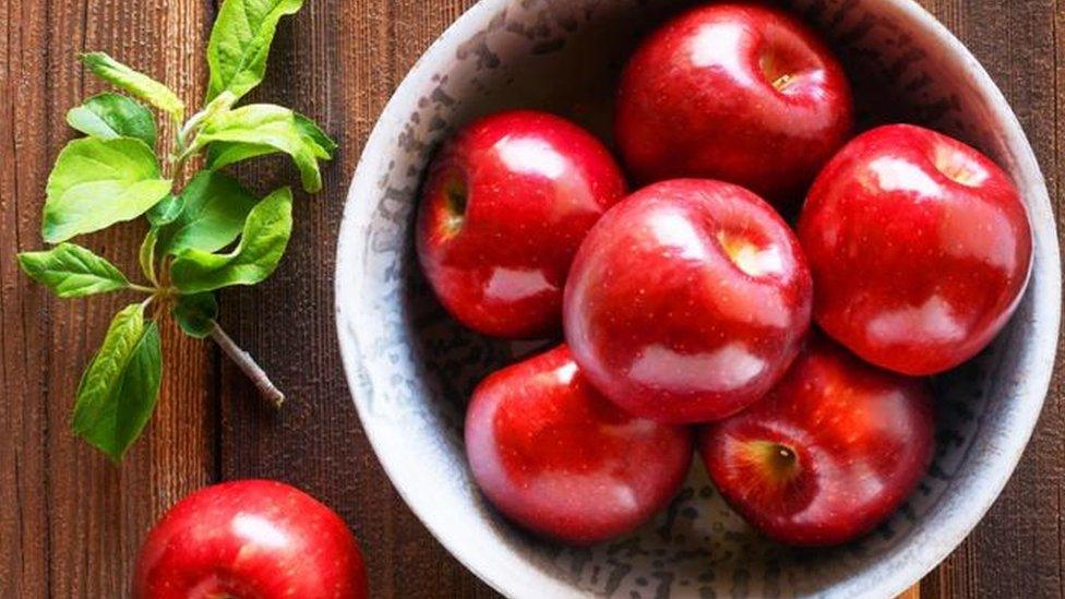 Shiny red apples in a bowl