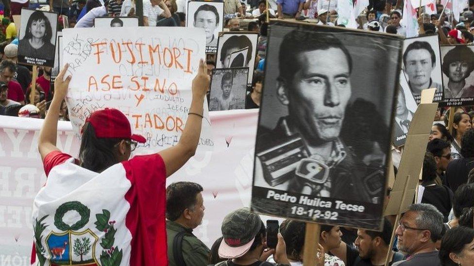 Protesters hold up banners during a demonstration against the pardon of ex-president Alberto Fujimori, in Lima, Peru, 25 December 2017