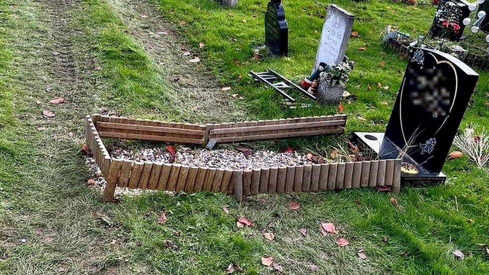 Grave with digger tracks going over it