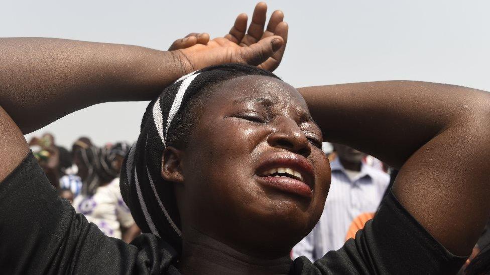 A woman cries during a funeral service