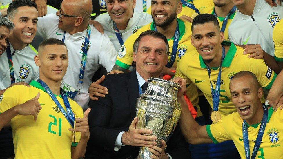 President of Brazil Jair Bolsonaro celebrates with the trophy and the players of Brazil after winning the Copa America Brazil 2019