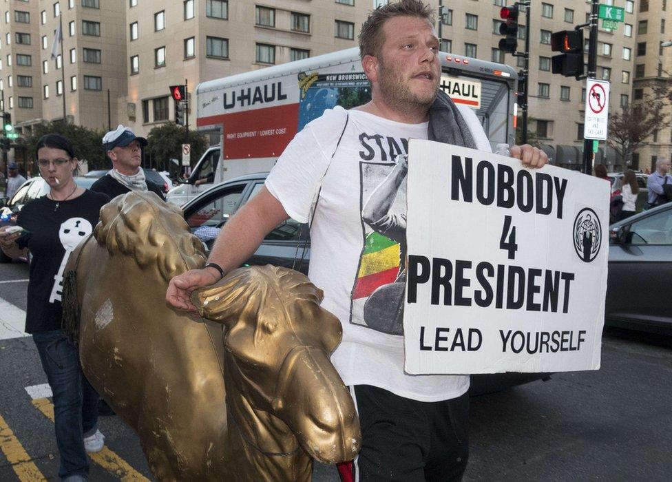 A man with a plastic camel marches with about 100 people during the Anonymous Million Mask March on the streets of downtown Washington, DC.