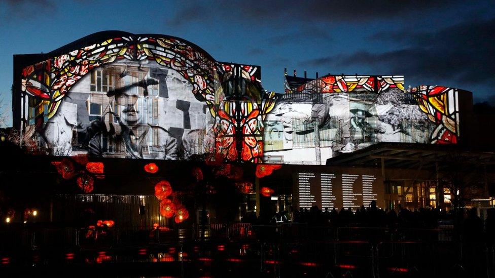 Scottish Parliament with names of war dead projected on to them