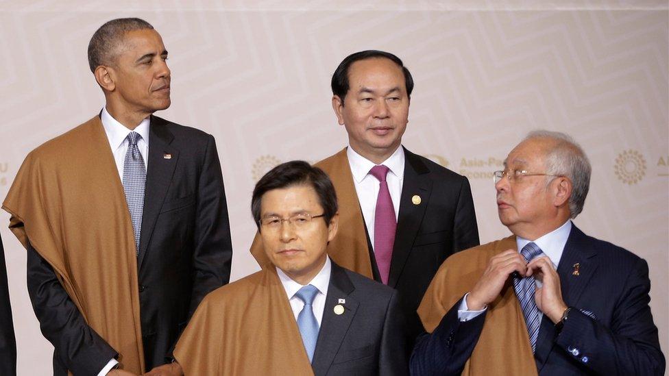 Malaysia's Prime Minister Najib Razak arranges his tie as he waits with U.S. President Barack Obama, top left, South Korea's Prime Minister Hwang Kyo-ahn, front left, and Vietnam's President Tran Dai Quang for the group photo at the annual Asia Pacific Economic Cooperation, APEC, summit in Lima, Peru, Sunday, Nov. 20, 2016. The APEC forum closed with a joint pledge to work toward a sweeping new free trade agreement that would include all 21 members as a path "sustainable, balanced and inclusive growth," despite the political climate.