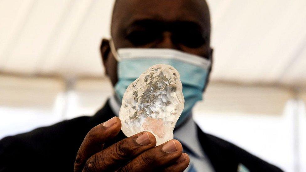 Botswana President Mokgweetsi Masisi holds the diamond in Gaborone, on June 16, 2021