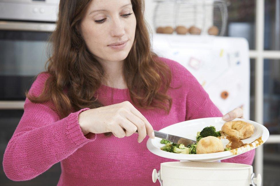 Woman scraping food into a bin