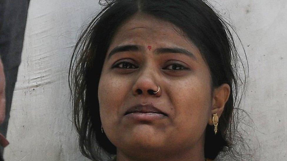 A woman crying outside a crematorium