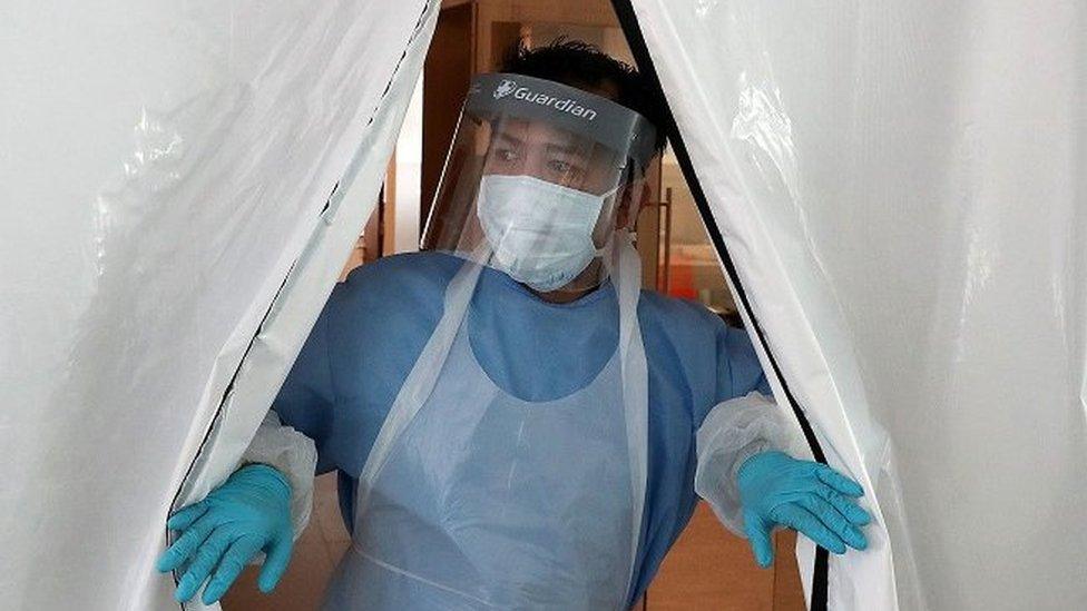 Technician in PPE at entrance to new laboratory