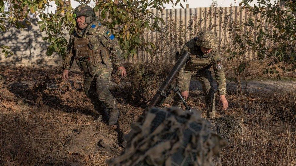 Ukrainian forces fire a mortar over the Dnipro river toward Russian positions