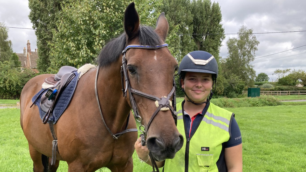 Horse rider standing next to horse