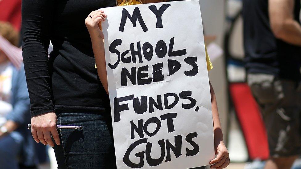 Sign reading My school needs funds not guns