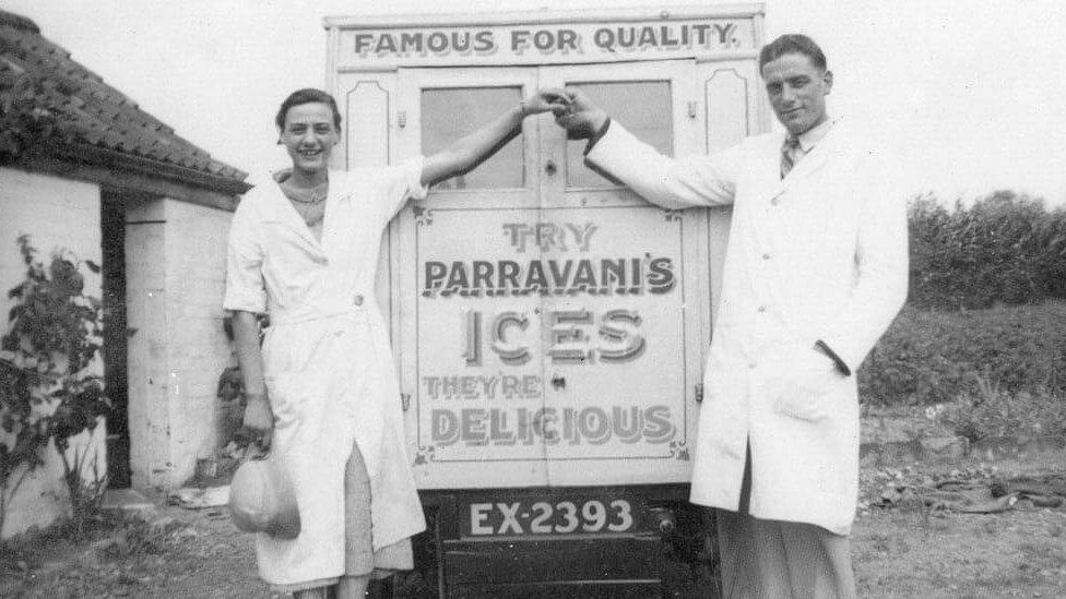 Black and white photo of man and woman with ice cream van