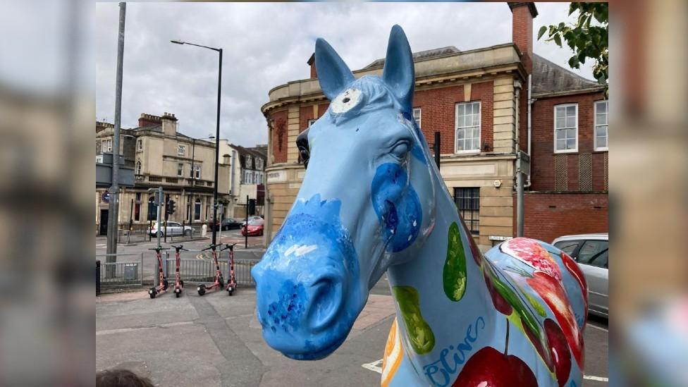 Blue unicorn statue on Gloucester Road in Bristol, missing its horn.