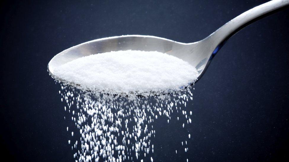 Sugar pouring from a spoon