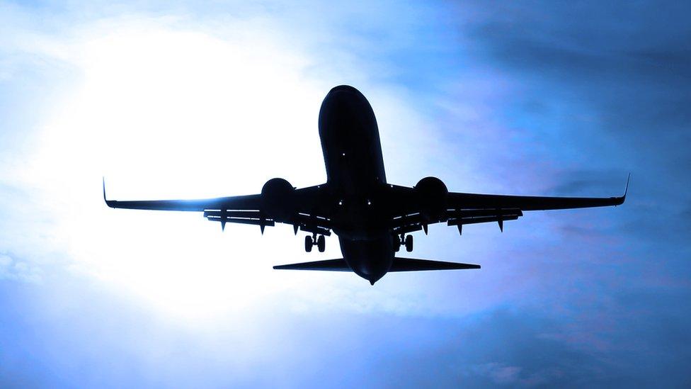 Plane silhouetted against the sky