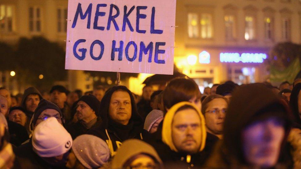 Supporters of the AfD political party protest against Chancellor Angela Merkel's liberal refugee and migrants policy on October 14, 2015 in Magdeburg