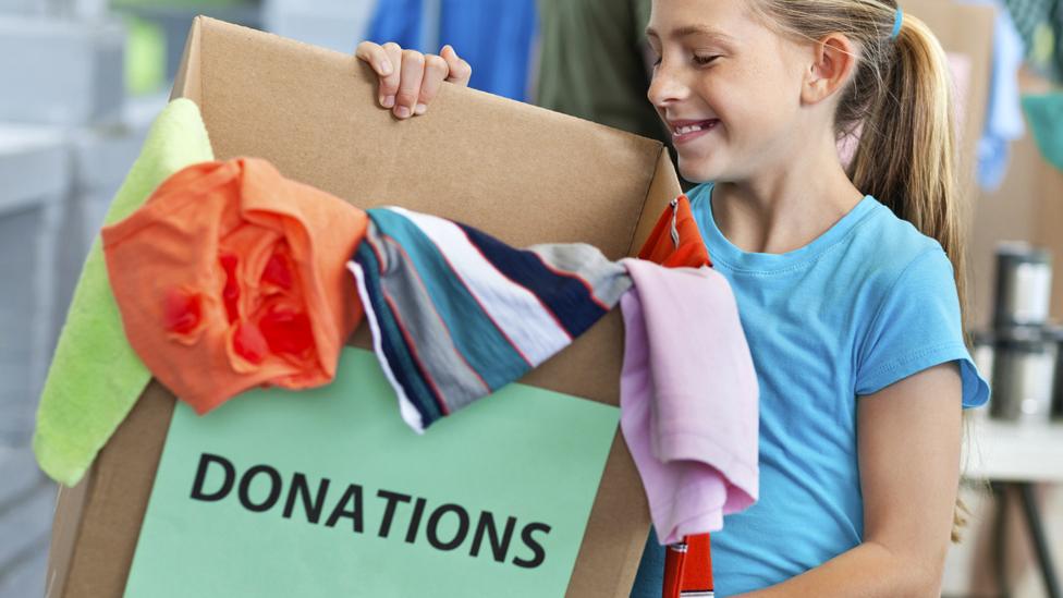 Girl with box of donated clothes