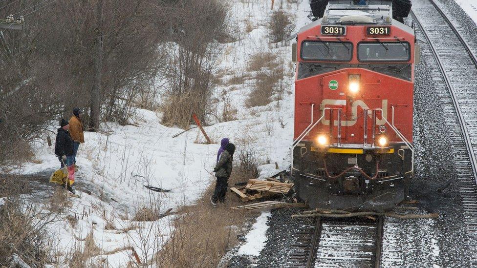 A CN Rail train moves by wooden pallets placed by occupants of a Mohawk Territory encampment