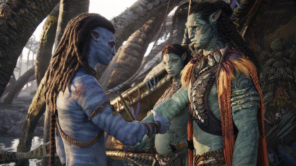 A still from Avatar: Way of the Water showing (left to right) Jake Sully, Ronal, and Tonowari.