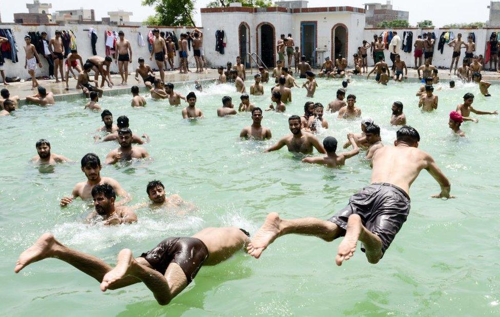 Indian youths play in a swimming pool on a hot summer day on the outskirts of Amritsar on June 2, 2019.