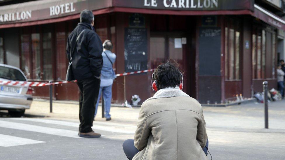 A woman sits outside of the Carillon bar in the 10th district of Paris on November 14, 2015,